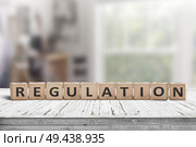 Regulation sign on a wooden table in a bright offive in daylight. Стоковое фото, агентство Ingram Publishing / Фотобанк Лори