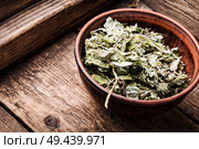 Dry leaves of coltsfoot on wooden background.Tussilago farfara.Dried coltsfoot. Dry leafs of coltsfoot. Стоковое фото, агентство Ingram Publishing / Фотобанк Лори