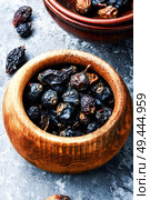 Dried red rose hips in bowl.Medicinal plants. Dry berry rose hips. Стоковое фото, агентство Ingram Publishing / Фотобанк Лори