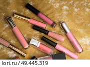 lip gloss in assortiment around golden backround. Стоковое фото, агентство Ingram Publishing / Фотобанк Лори
