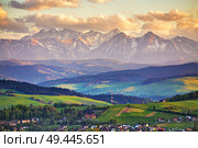 Snow caped mountains and green fields and meadows in Malopolska region, Poland. Spring sunset in Tatra Mountains, Pieniny range. Стоковое фото, агентство Ingram Publishing / Фотобанк Лори