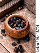 Dried red rose hips in bowl on a wooden rustic table. Dog rose on wooden background. Стоковое фото, агентство Ingram Publishing / Фотобанк Лори