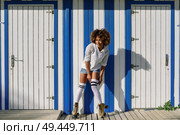 Young black woman on roller skates near a beach hut. Girl with afro hairstyle rollerblading on sunny promenade.. Young black woman on roller skates near a beach hut. Стоковое фото, агентство Ingram Publishing / Фотобанк Лори