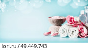 Beautiful pink white spa setting with towels, flowers, candles, sea salt and body care cosmetics at light blue background with bokeh, banner. Beauty concept. Стоковое фото, агентство Ingram Publishing / Фотобанк Лори