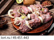 Fresh raw meat skewers kebabs on plate.Meat prepared for marinating on cutting board. Skewers of shish kebab. Стоковое фото, агентство Ingram Publishing / Фотобанк Лори
