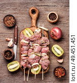 Making kebabs-raw meat on skewers on aged wooden background. Beef skewer kebab. Стоковое фото, агентство Ingram Publishing / Фотобанк Лори