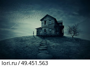Young man stand at the corner of a ravaged house, looking far away for someone. A ghost, desolated house with a dry land and tree. . Стоковое фото, агентство Ingram Publishing / Фотобанк Лори