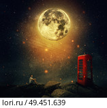 Imaginary view as a young man sitting on the cliff, wait for someone to call him at the phone booth (box). Full moon night with a starry sky background. Loyalty and hard determination concept. Стоковое фото, агентство Ingram Publishing / Фотобанк Лори