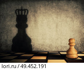 Pawn chess piece glorification, casting a shadow of coronation on a concrete wall. Business aspirations and leadership concept. Magical transformation, become a king. Стоковое фото, агентство Ingram Publishing / Фотобанк Лори