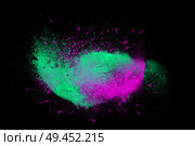 Freeze motion of colorful powder paint exploding isolated on black dark background. Abstract design of color dust cloud. Particles explosion screen saver, wallpaper, brush. Стоковое фото, агентство Ingram Publishing / Фотобанк Лори