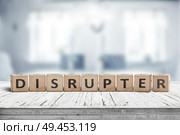 Disrupter sign on an office desk on a bright blue room in daylight. Стоковое фото, агентство Ingram Publishing / Фотобанк Лори