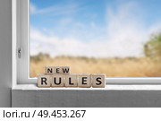 New rules sign in a window with a view to fields under a blue sky. Стоковое фото, агентство Ingram Publishing / Фотобанк Лори