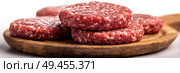A stack of meat patties on a wooden cutting board. Стоковое AI-изображение, AI-художник Ярославский Максим / Фотобанк Лори