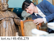 lady inspecting antique chair. Стоковое фото, агентство Ingram Publishing / Фотобанк Лори