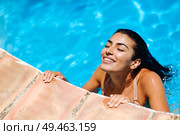 Beautiful Arab woman relaxing in swimming pool with eyes closed. Girl with healthy tanned skin and wet hair enjoying Summer Sun.. Beautiful Arab woman relaxing in swimming pool. . Стоковое фото, агентство Ingram Publishing / Фотобанк Лори