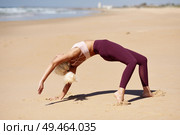 Caucasian woman practicing yoga at seashore. Young female standing in bridge pose in the beach in Cadiz, Andalusia, Spain.. Caucasian blonde woman practicing yoga in the beach. Стоковое фото, агентство Ingram Publishing / Фотобанк Лори