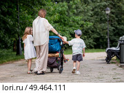 A family with three children. A mother with many children and toddlers in a summer park. Children are walking in the fresh air. Having many children and family values. Стоковое фото, фотограф Photojuli / Фотобанк Лори