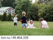 A family with three children. A mother with many children and toddlers in a summer park. Children are walking and flying a kite. Large families, family values, and leisure time with children. Стоковое фото, фотограф Photojuli / Фотобанк Лори