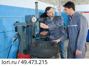 car mechanic repairing tire at the car repair shop. Стоковое фото, агентство Ingram Publishing / Фотобанк Лори