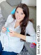 Young lady sat on floor knitting. Стоковое фото, агентство Ingram Publishing / Фотобанк Лори