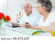 Elderly couple studying a map and using a notebook. Стоковое фото, агентство Ingram Publishing / Фотобанк Лори