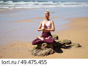 Caucasian woman practicing yoga at seashore. Young female doing lotus pose in the beach in Cadiz, Andalusia, Spain.. Caucasian blonde woman practicing yoga in the beach. Стоковое фото, агентство Ingram Publishing / Фотобанк Лори