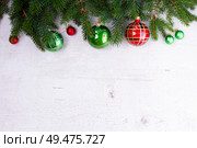 Evergreen fir tree twigs with red and green decorations, flat lay boder on white wooden background. Green and red christmas. Стоковое фото, агентство Ingram Publishing / Фотобанк Лори