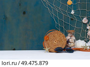 Summer sea still life with straw bag, seashells and fishing net with copy space. Summer sea still life. Стоковое фото, агентство Ingram Publishing / Фотобанк Лори