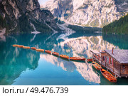 Wooden boats in a row on summer morning at Lago di Braies (also known as Pragser Wildsee) in Dolomites Mountains, Sudtirol, Italy.. Wooden boats in a row on summer morning at Lago di Braies, Italy. Стоковое фото, агентство Ingram Publishing / Фотобанк Лори