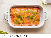 Close up of raw salmon fillet with dill in white casserole on light background, top view. Healthy seafood concept. Diet food. Omega 3. Стоковое фото, агентство Ingram Publishing / Фотобанк Лори