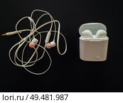 Comparison between tangled wired headphones versus wireless earphones for music listening. Pros and cons, opposite contrary. Technology development tendencies, human entertainment conveniences concept. Стоковое фото, агентство Ingram Publishing / Фотобанк Лори