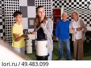 Kids solving conundrum in escape room and grandparents watching them. Стоковое фото, фотограф Яков Филимонов / Фотобанк Лори