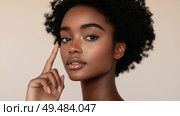 Captivating portrait of a young woman with natural curls showcasing effortless beauty in a soft light setting. Стоковое AI-изображение, AI-художник Сергей Толмачёв / Фотобанк Лори