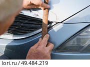 Car body shop. Repair man processes the welding seam using an angle grinder on replaced car part. Professional Body master grind old paint and rust. Rust damage. Rusting car. Hands with tool close-up. Стоковое фото, фотограф Марина Демидюк / Фотобанк Лори