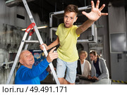 Boy pointing to something while trying to find solution of conundrum with relatives in quest room. Стоковое фото, фотограф Яков Филимонов / Фотобанк Лори