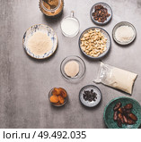 Healthy vegan diet ingredients bowls : cashew , almond flour, Coconut cream, non dairy milk, agar agar, Coconut butter, dried fruits on concrete background, top view. Plant based and Low-calorie diet. Стоковое фото, агентство Ingram Publishing / Фотобанк Лори
