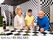Grandparents with teenager boy discuss the game in chess quest room. Стоковое фото, фотограф Яков Филимонов / Фотобанк Лори
