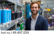 Engineer stands proudly in battery research facility showcasing innovations in energy storage technology. Стоковое AI-изображение, AI-художник Сергей Толмачёв / Фотобанк Лори
