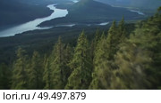 Aerial view of lush green forest and winding river in mountainous terrain. Стоковое AI-видео, аниматор Андрей Бажанов / Фотобанк Лори