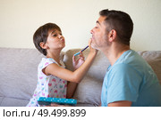 Little cute daughter doing make-up to her father. Dad spending free time with her daughter. Alternative masculinity concept.. Little cute daughter doing make-up to her father. Стоковое фото, агентство Ingram Publishing / Фотобанк Лори