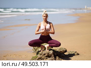 Caucasian woman practicing yoga at seashore. Young female doing lotus pose in the beach in Cadiz, Andalusia, Spain.. Caucasian blonde woman practicing yoga in the beach. Стоковое фото, агентство Ingram Publishing / Фотобанк Лори