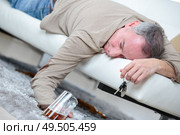 drunk businessman sleeping with beer on a sofa. Стоковое фото, агентство Ingram Publishing / Фотобанк Лори