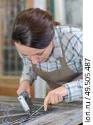 Woman applying lead to stained glass. Стоковое фото, агентство Ingram Publishing / Фотобанк Лори