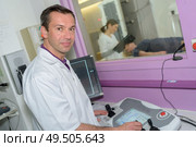 male radiologist taking xray of man. Стоковое фото, агентство Ingram Publishing / Фотобанк Лори