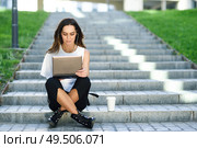 Middle-age businesswoman working with her laptop computer sitting on urban steps outdoors.. Young woman working with her laptop computer sitting on the floor. Стоковое фото, агентство Ingram Publishing / Фотобанк Лори