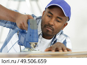 man cuts a board in workshop. Стоковое фото, агентство Ingram Publishing / Фотобанк Лори