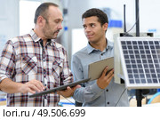 electricians measuring solar panels prior to installing them. Стоковое фото, агентство Ingram Publishing / Фотобанк Лори