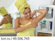 woman puts deodorant on armpits. Стоковое фото, агентство Ingram Publishing / Фотобанк Лори