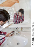 a plumber fixing a tap. Стоковое фото, агентство Ingram Publishing / Фотобанк Лори