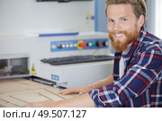 man passing wood through industrial router. Стоковое фото, агентство Ingram Publishing / Фотобанк Лори